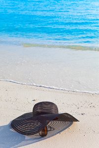 太阳镜和帽子躺在海边的沙滩上