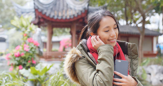 女子听音乐, 穿冬季夹克在中国花园