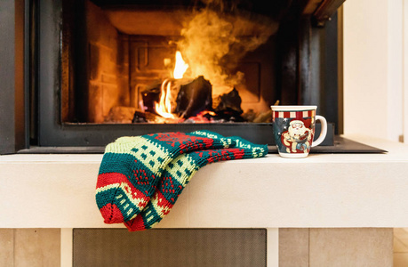 毛的袜子和圣诞壁炉杯。靠近脚冬季和圣诞节假期概念