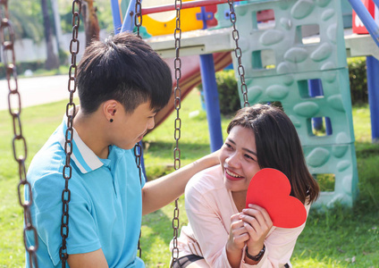 浪漫的年轻情侣在公园里展示爱心和关爱, 情人节