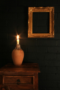 黑色砖墙上的金框和蜡烛