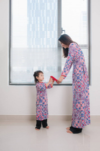 越南妈妈和女儿在 Ao 傣族的传统服饰上, 过年在家过年。春节假期