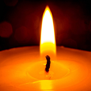 在黑暗的特写中燃烧蜡烛的火焰