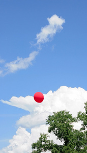 天空背景下的红色气球和云