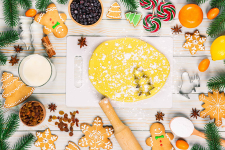 烹调圣诞姜饼饼干与配料, 面团, 糖果和冬季香料装饰在白色的木桌上庆祝新年。圣诞食品背景