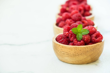红 rasberries 果在木碗桌上