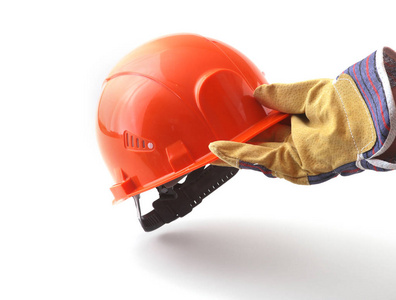 戴着防护手套的工人手里拿着一顶橙色的安全帽。安全帽