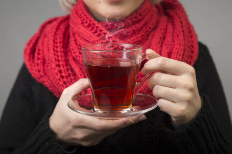 穿着比基尼的美女喝饮料年轻的黑发美女在咖啡馆的红沙发上喝着一杯