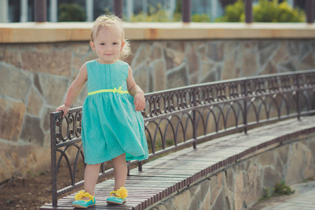 可爱的小女婴在中央公园享受夏日时光穿着五颜六色的连衣裙和凉鞋与金发和粉红色的脸颊