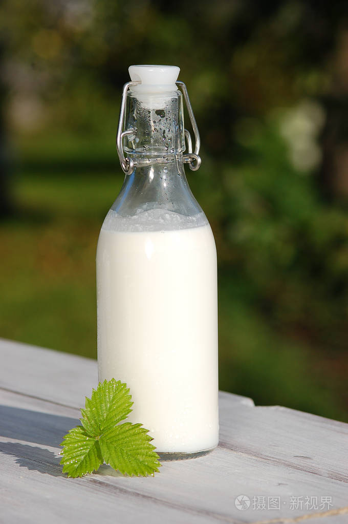 在木桌上的瓶子里的牛奶
