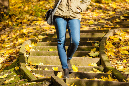 站在秋天的公园在楼梯上的女人