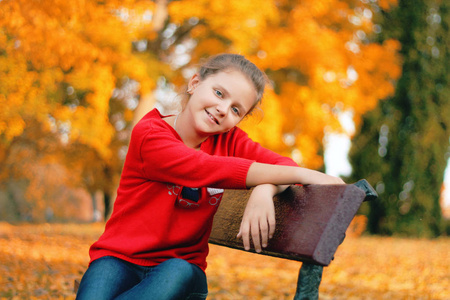 一个女孩坐在公园的长凳上