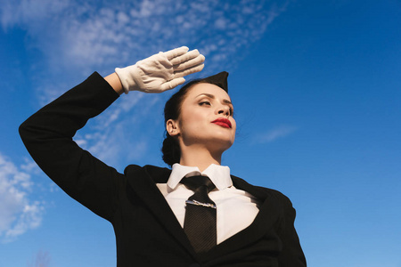 女子空姐在天空背景下摆出制服