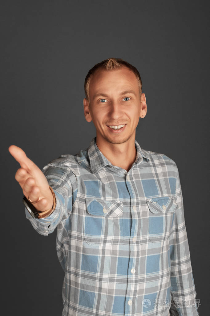 微笑的年轻男子提供握手.问候和欢迎手势