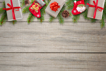 木桌上的圣诞作文。礼品, 袜子, 松果和冷杉树枝在上面。文本的可用空间。顶部视图