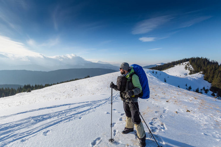 登山者在冬天的山上向摄影机摆姿势