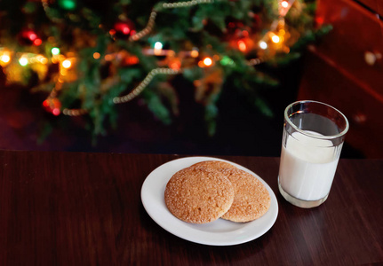 圣诞饼干和牛奶以票据为圣诞老人灯位前