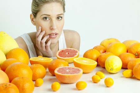 有柑橘类水果的年轻女子画像