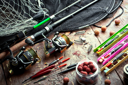 钓鱼竿和 spinnings 在构成与配件为钓鱼在老背景在桌上