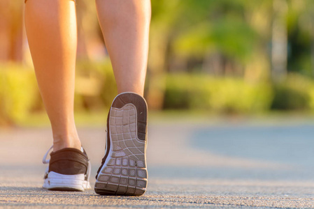 跑步者脚在户外运动公园的路上奔跑, 在鞋上特写。亚洲健身女性跑步是为了健康和放松。体育概念