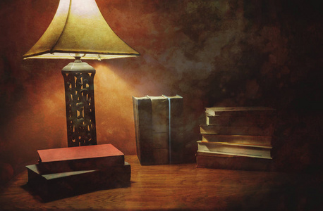 一摞精装书在木桌与灯图片