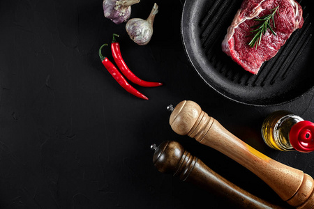 新鲜生肉牛柳和大理石牛排烧烤锅和油炸板调味, 黑色背景顶部视图