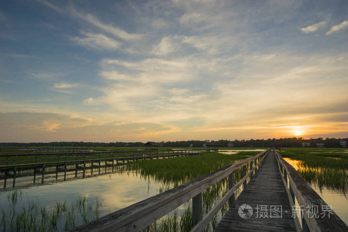 在美丽的夜空下, 夕阳下的小溪和障碍岛上的木板路