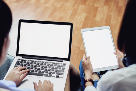 坐在黑沙发上的女人用电脑和空白的屏幕板。图形的空白屏幕。数字技术在日常生活中的概念