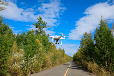 飞越秋季森林的无人机飞过公路