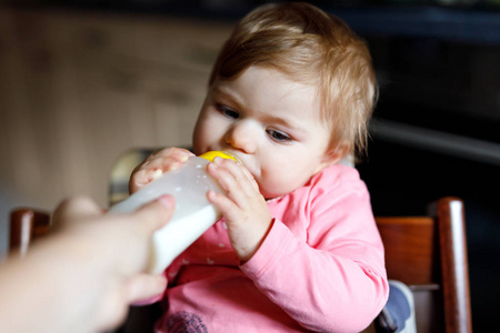 可爱可爱 ewborn 的女婴孩抱着奶瓶喝配方奶
