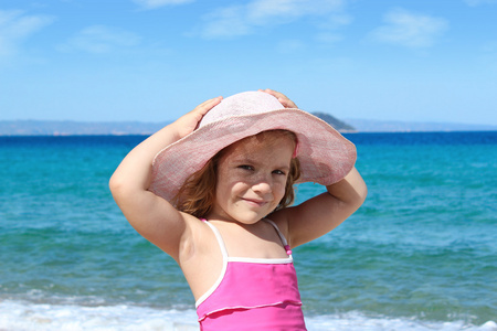海滩上的草帽的小女孩