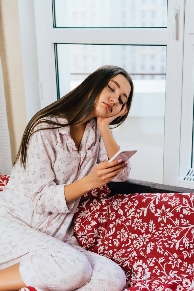 穿着睡衣的困女看着电话