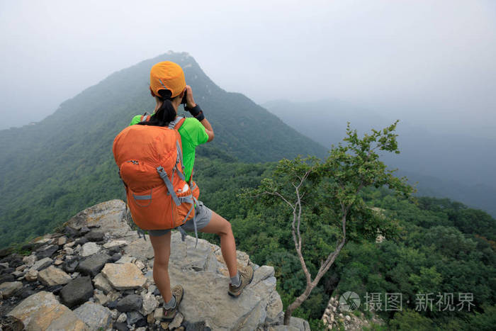 女登山者在山顶拍照