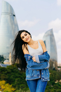在阿塞拜疆巴库, 有吸引力的长发女孩在现代建筑中冒充背景