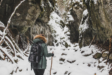 在冰雪覆盖的高山峡谷漫步的女孩