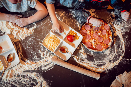 制作比萨饼的过程。孩子们在家里做披萨