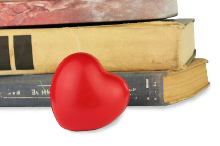 在白色背景和红色心脏被隔绝的老书堆