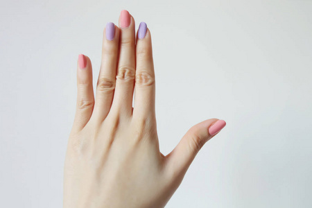 关闭指甲油指甲。美丽的女人是粉红色的手和紫罗兰色的白色背景, 伟大的任何使用