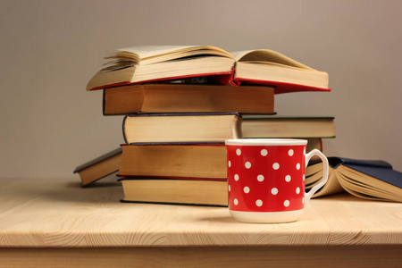 瓷红色杯子和一摞书在木桌