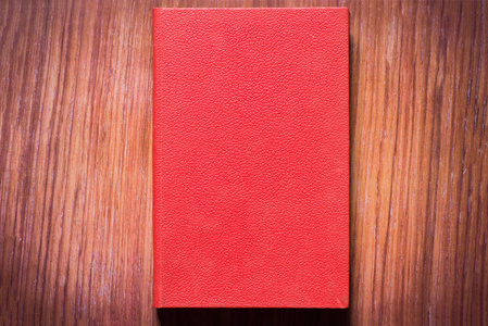 棕色桌子上的一本红色的书