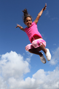 快乐的飞跃年轻女孩获得巨大成功
