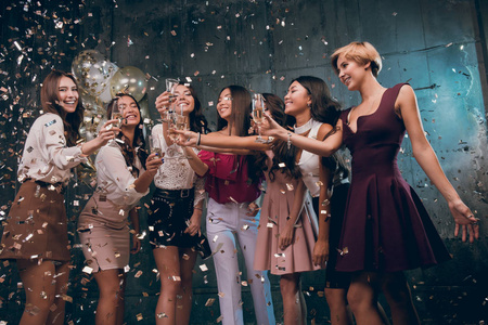 庆祝与乐趣。性格开朗的年轻女孩，携带香槟酒杯金五彩纸屑的歌舞组。在 2018 年最佳方。新年快乐