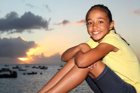 在海边欣赏日落的年轻女孩