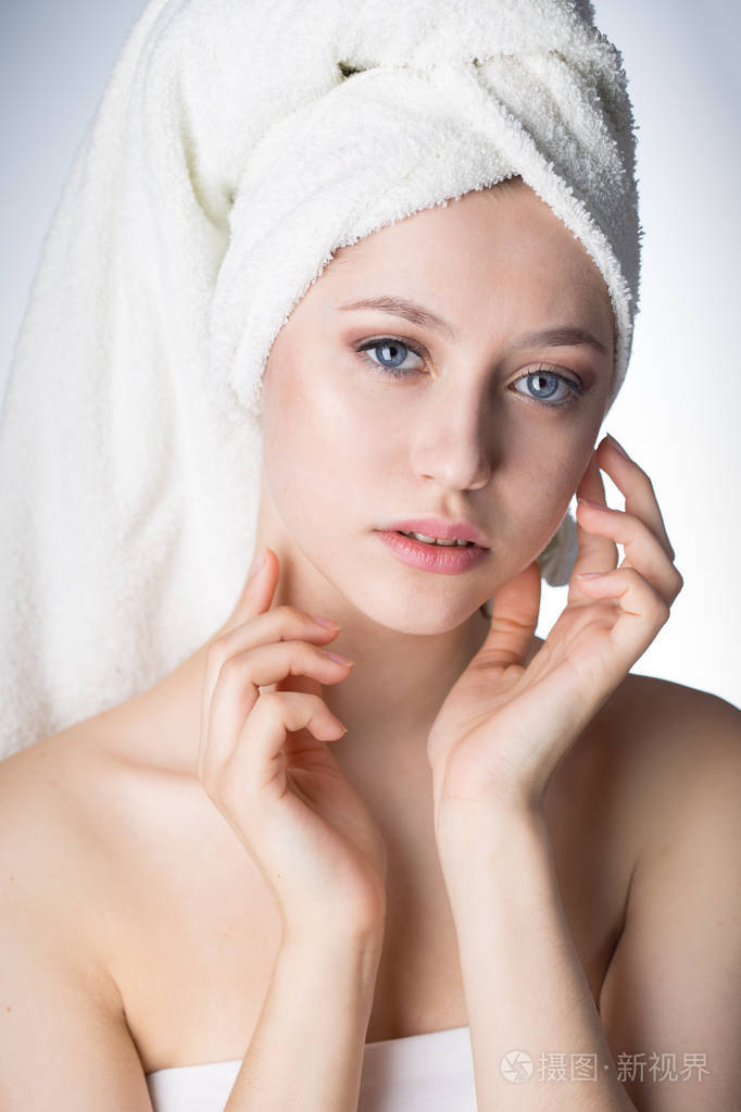 美丽的年轻女子,用毛巾擦脸