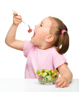 可爱的小女孩吃蔬菜沙拉