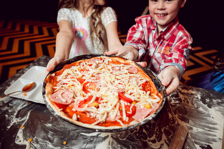 制作比萨饼的过程.孩子们在家里做披萨照片