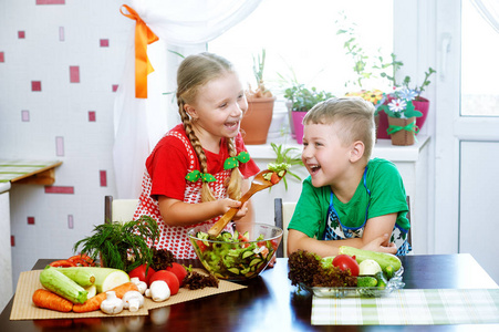 有趣的孩子们准备沙拉蔬菜。厨房里的快乐孩子健康素食的概念