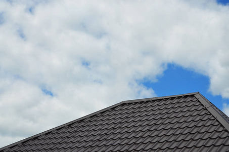 棕色屋顶瓷砖或瓦在房子作为背景图像。新的重叠棕色经典风格屋面材料纹理图案在一个实际的房子