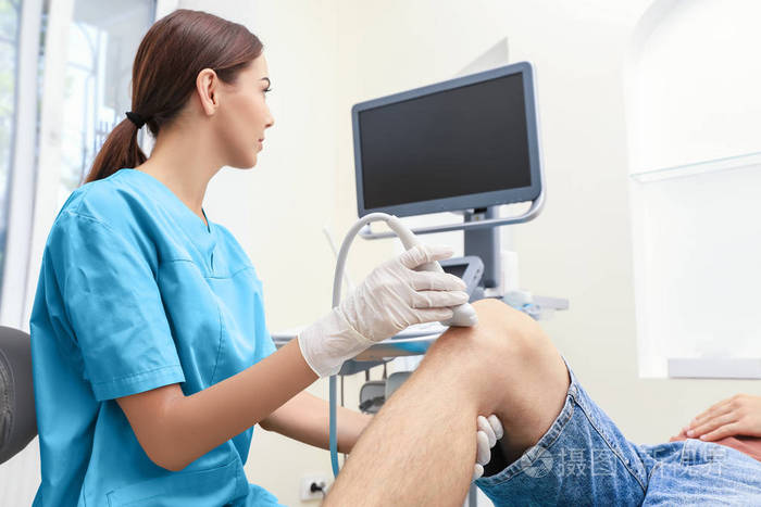 医生进行超声检查的病人的膝盖在诊所