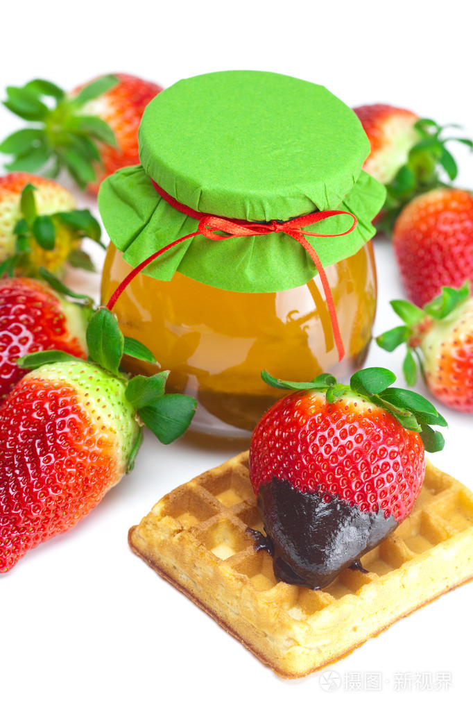 巧克力中的大而多汁的成熟草莓一罐蜂蜜和面包